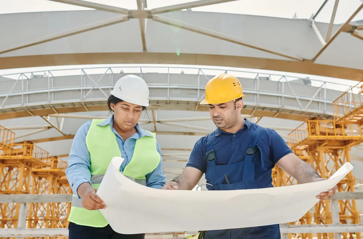 Deux ingénieurs consultant un plan sur un chantier